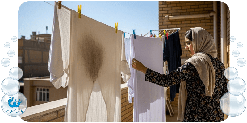 لباس‌های شسته شده و تمیز (از جمله لباس لکه‌گیری شده) که زیر نور مستقیم خورشید روی بند رخت یک بالکن ایرانی آویزان شده‌اند.