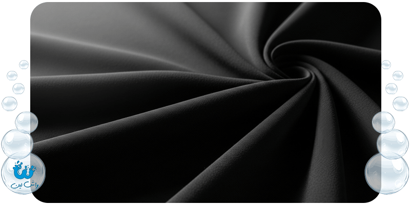 تصویر ماکرو از پارچه چادر مشکی که پس از خشکشویی تخصصی، رنگ مشکی و عمیق خود را حفظ کرده است.