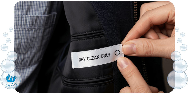 دست در حال بررسی دقیق برچسب مراقبتی داخل کت با علامت "فقط خشکشویی"؛ تاکید بر اهمیت خواندن دستورالعمل پیش از هر اقدام.