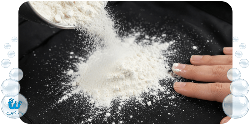 پاشیدن پودر نشاسته ذرت روی لکه روغن تازه کت؛ نمایش روش خانگی جذب چربی از روی پارچه.