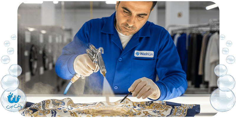 متخصص خشکشویی واشلین در حال استفاده از دستگاه لکه‌بری تخصصی روی پارچه ابریشمی، نماد لکه بری پارچه ظریف.