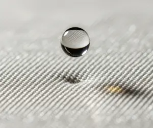 عکس ماکرو از یک قطره روغن در حال افتادن روی پارچه ابریشمی، نماد پاک کردن لکه‌های سرسخت از لباس‌های حساس.