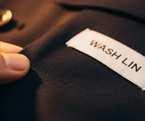 نمای نزدیک از بافت پارچه کت و شلوار تمیز و اتوکشی شده با تگ برند واش لین