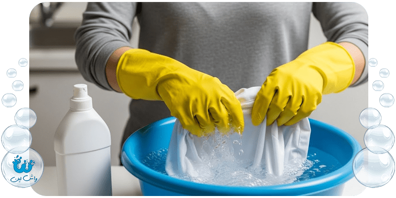 خیس کردن لباس سفید در محلول آب و وایتکس با دستکش ایمنی - مراحل لکه بری